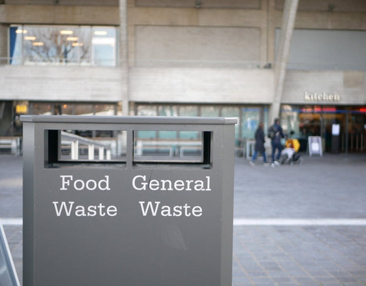 A rubbish bin for food waste and general waste in front of a building