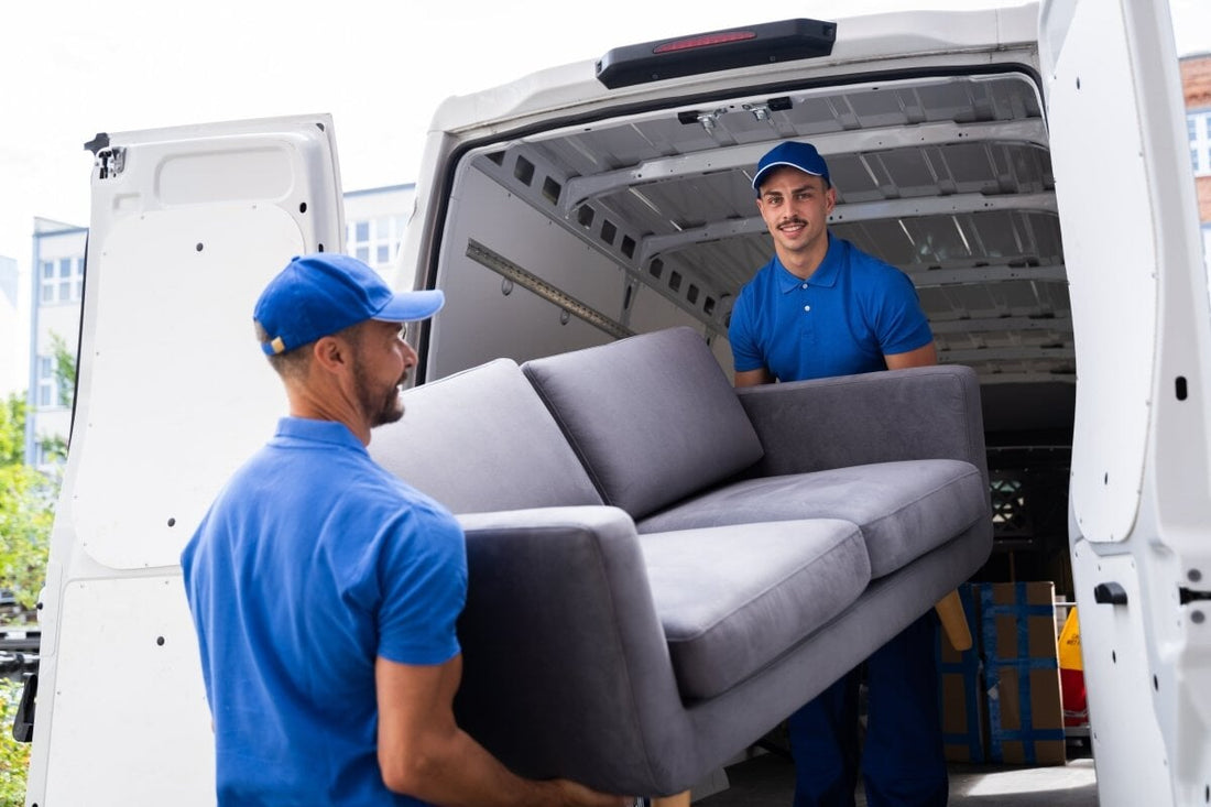 two men lifting and moving a sofa into a van