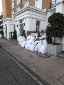 a photo of a bunch of rubbish removal bags waiting for collection